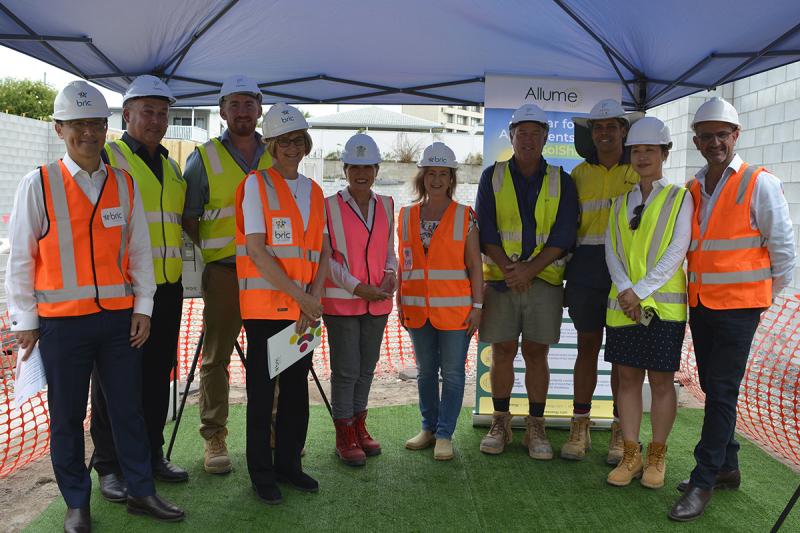 A group of bric & Queensland Government representatives are on a building site.