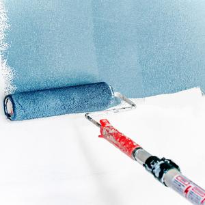A paint roller is applying blue paint